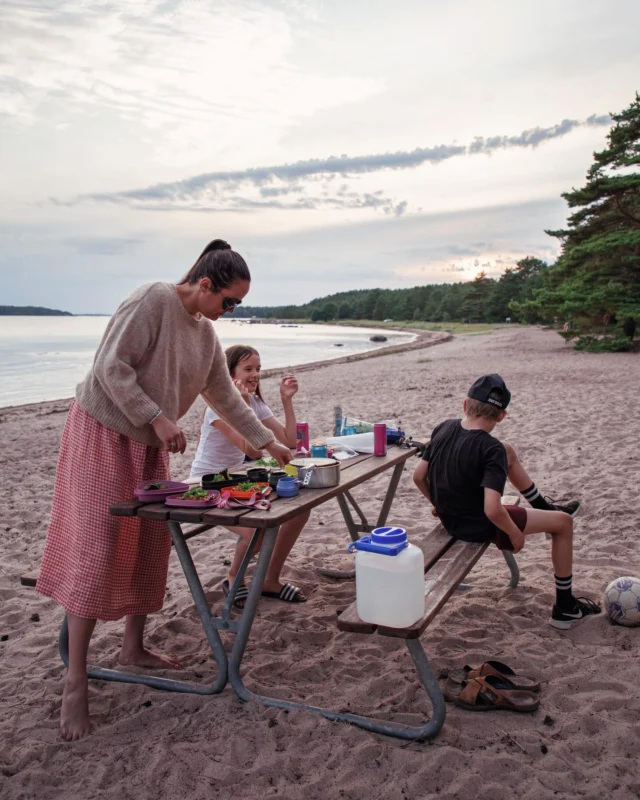 Padva beach – ranta kuin Muumilaaksossa 🐚
 
Höpönassut retkikavereina, teltta vuokra-auton takakontissa ja ranta kuin satukirjoista. Sillä kattauksella oli ihana kesälomalla aloittaa länsirannikon road trip.
 
Puoliso oli käynyt tällä, reteästi englanniksi nimetyllä Badva Beachilla aikaisemmin kalastusreissuillaan. Hän arvasi oikein, kun oli tuumaillut meidänkin varmasti pitävän Raaseporin läntisimmässä kolkassa sijaitsevasta kuunsirpin muotoisesta rannasta.
 
Badvan hiekka on valkoista ja rannalle on huuhtoutunut linnunsulkia sekä erimuotoisia ja -värisiä näkinkenkiä. Oli uskomattoman kaunis kesäisen sadepäivän jälkeinen ilta. Kuljimme pitkin rantaa aarteita tutkien, pienen kourallisen kauneimpia taittelimme varovasti silkkihuiviin matkamuistoksi.
 
Vesi Padvan rannalla on pitkälle matalaa, mereen sai kahlata pehmeässä hiekassa kymmeniä metrejä päästäkseen niin syvälle, että pystyi uida. Meriveden kirkkaudesta saattoi päätellä, että olimme syvällä saaristossa. Tuoksussakin oli enemmän syvyyttä: suolaa, vihreyttä ja jotain sellaista rehevän mehevää, mikä tuoksuu vain saaristossa. Ehkä joku vesikasvillisuus, jota ei Helsingin rannoilla kasva?
 
Harvakseltaan meressä, hiekan keskellä, pilkisteli rakkohaurukiviä; mustia kiviä, joista kasvoi rehevänä rakkohaurua. Olisipa ollut uimalasit mukana, että olisi voinut tutkailla, mitä kaikkia pikkuotuksia Itämeren avainlaji piteli lehviensä suojassa. Luin, että rakkohauruissa elelee esimerkiksi sinisimpukoita, leväkatkarapuja ja monien lajien poikasia, kuten ahvenia ja haukia.
 
Auringon alkaessa laskea, pystytimme teltan etäämmälle rannasta. Parkkipaikalla oli muutama matkailuauto puskaparkissa, kauempaa vuokramökeiltä kuului ilakointia. Illallisen katoimme rannan pöytäryhmän luo. Rannan huussissa pystyi hoitaa iltatoimiin kuuluvat vessaosiot.
 
Yöllä heräsin sateen ropistessa teltan kattoon, lempiääniäni. Aamulla taivas oli taas selkeä, kun kömmin puuron tuoksun houkuttelemana lähes kymmentuntisilta yöuniltani. Puoliso ja kuopus olivat käyneet hakemassa lähimetsästä, parkkipaikan viereen hakatun raiskion takaa, mustikoita puuron päälle.
 
Lähdimme jatkamaan matkaa uikkarit vuokra-auton penkeistä kosteina roikkuen 💖